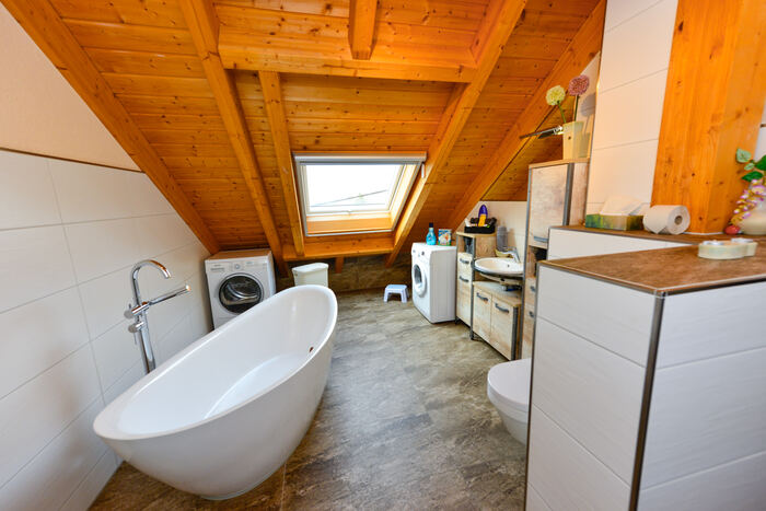 Freistehende Badewanne unter dem Dachfenster