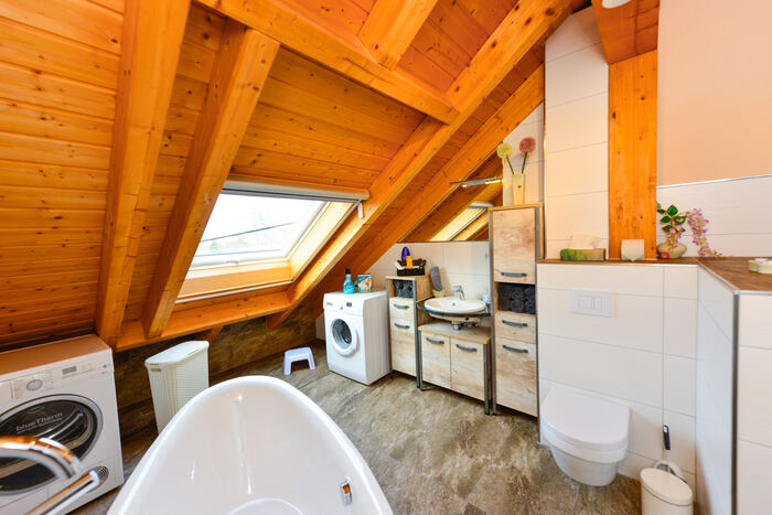 Badezimmer mit Wanne, WC und Waschmaschine