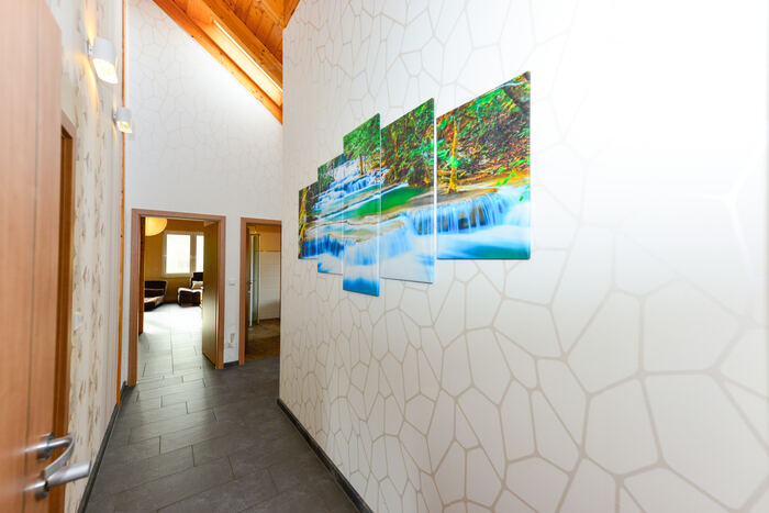 Flur mit Wandbild und Blick in den Wohnbereich